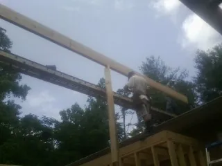 Carpenter setting a ridge beam over a new addition frame — Ice Dam Removal by Roofing Brothers in Wabasso