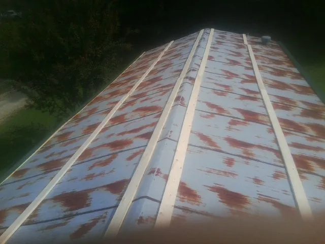 Rusted metal roof panels with new wood purlins before replacement — Storm Damage Roof Repair in Wabasso by Roofing Brothers